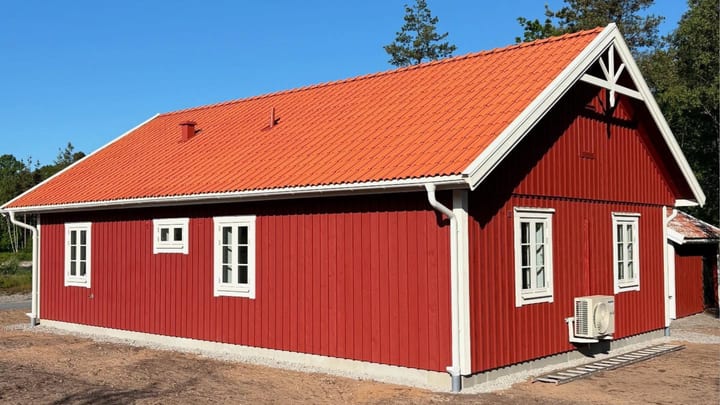 Fasad och tak – DNA Kalmar-Öland Bygg Nybyggd villa på Öland – rött trähus med vita knutar och nytt tegeltak.