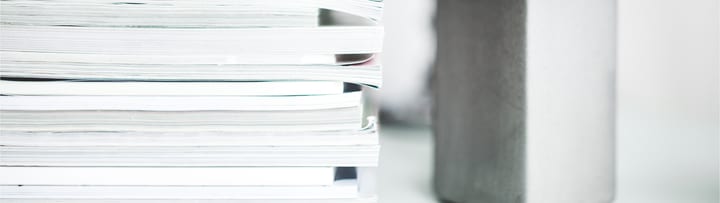 Närbild av staplade dokument på skrivbord.