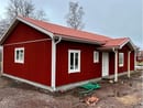 Nybyggt hus med röd träfasad och tegeltak.